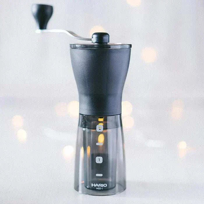 Molino de café manual HARIO Mini Slim Plus, muelas de cerámica, diseño compacto y versátil.