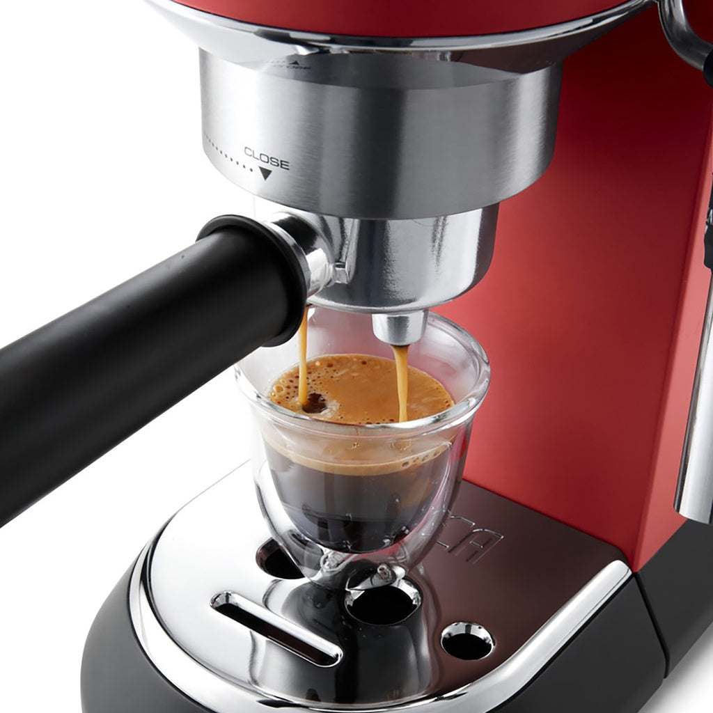 Delonghi Dedica red espresso machine brewing coffee.