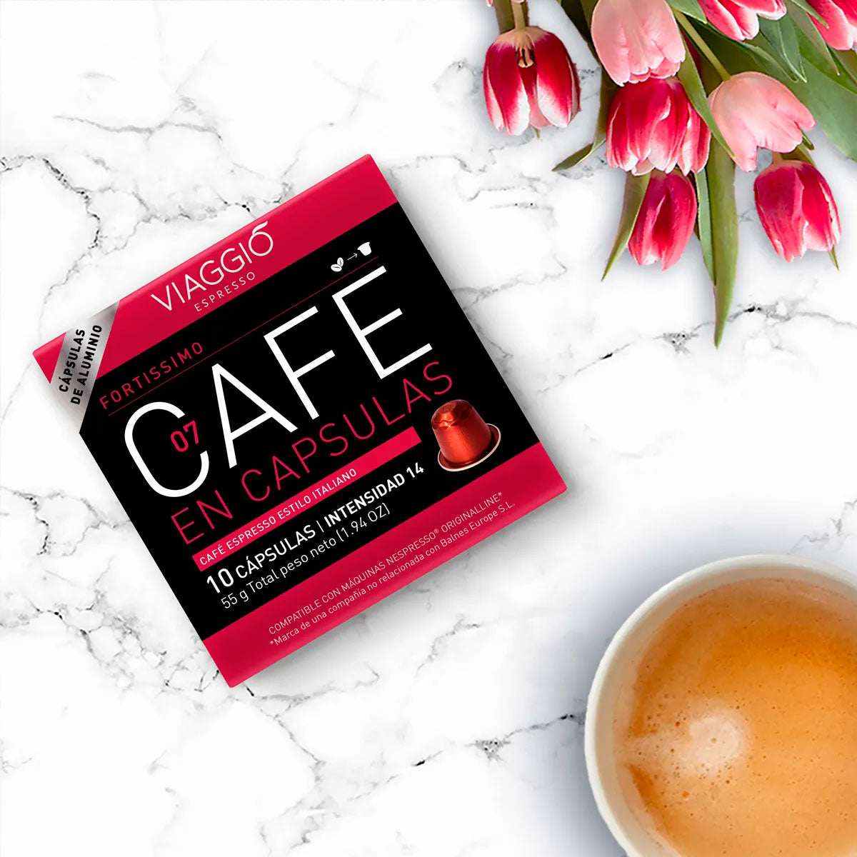 Viaggio Fortissimo coffee capsules compatible with Nespresso, box of 10 capsules next to a cup of espresso and pink tulips on marble surface