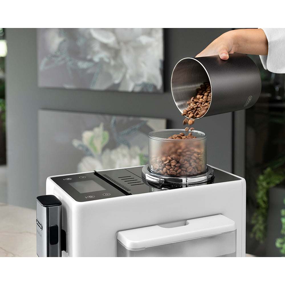 Delonghi superautomática Rivelia coffee machine with beans being poured into the hopper.