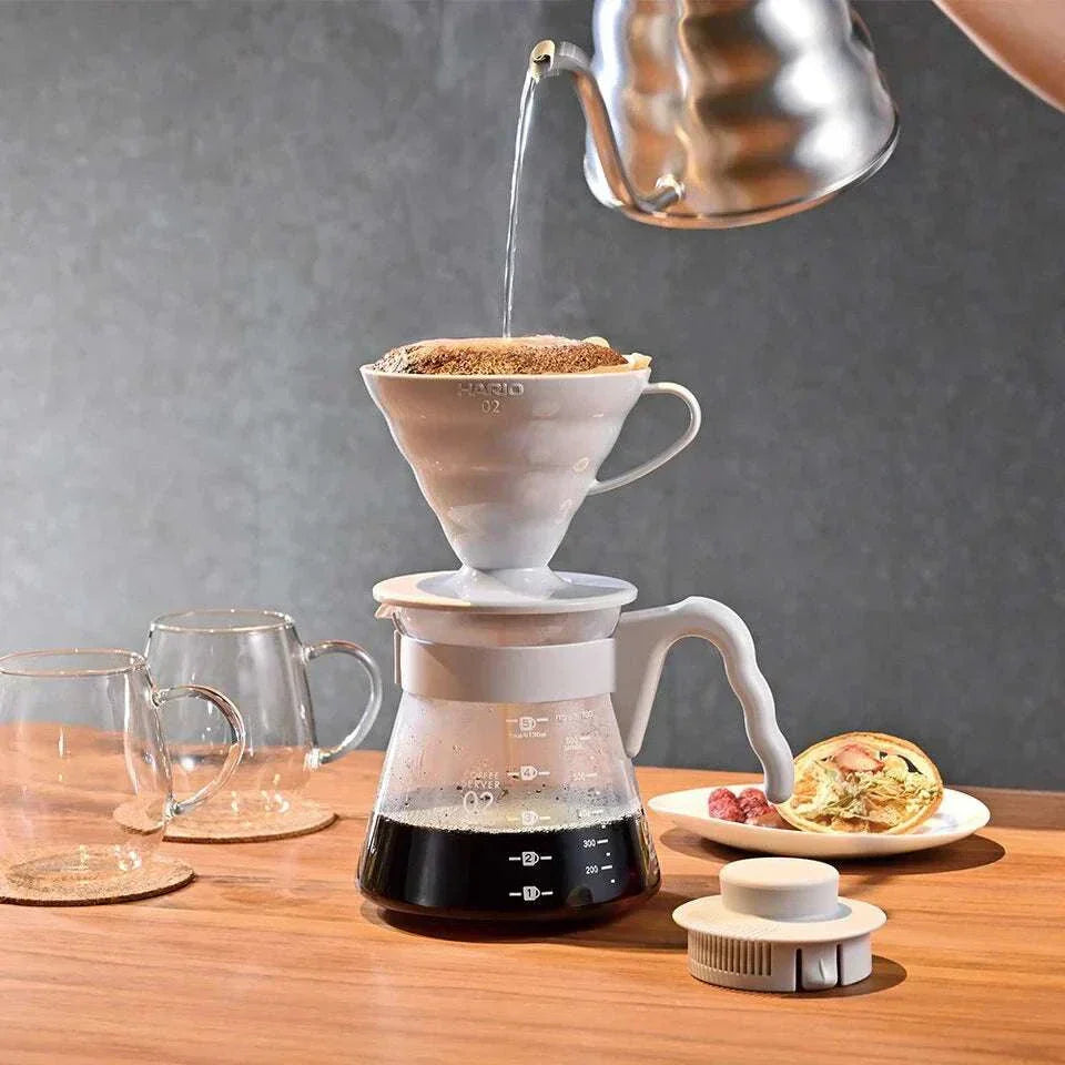 Kit de V60 V60 pour over coffee maker with glass server brewing fresh coffee on wooden table